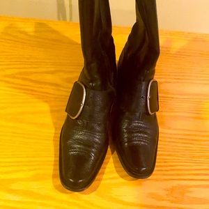 Black leather boot with large buckle.